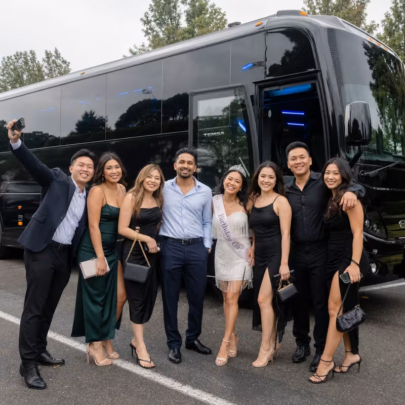 Group boarding a white charter bus for Birthday Transportation transportation in Fremont
